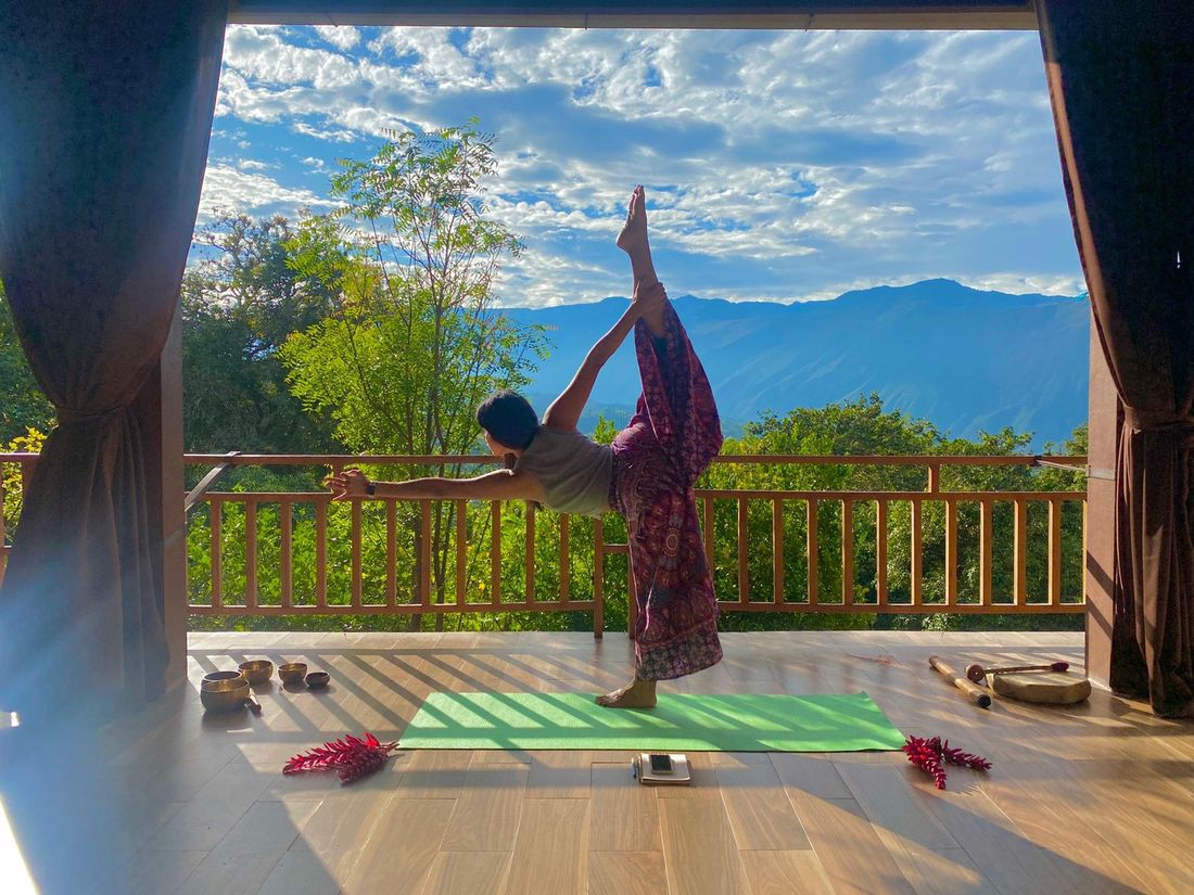 Práctica de yoga en una terraza con vista a las montañas